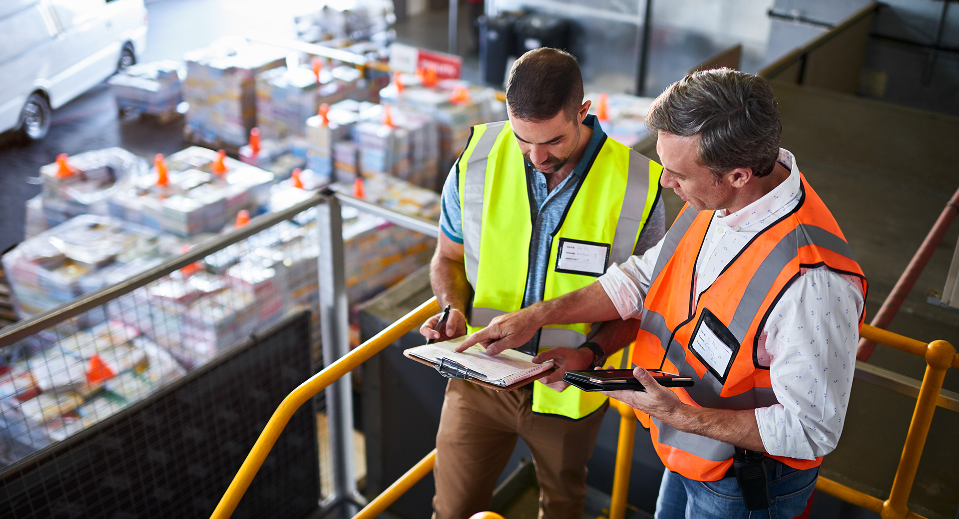 two men comparing logistics information in a warehouse